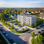 Nowe Szafranki Ostróda – widok z drona na nowoczesny budynek mieszkalny z balkonami, parking i zieleń wśród spokojnej zabudowy jednorodzinnej